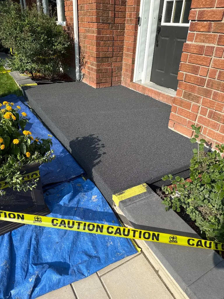 Front porch and step finished with a charcoal quartz coating, taped off while it cures