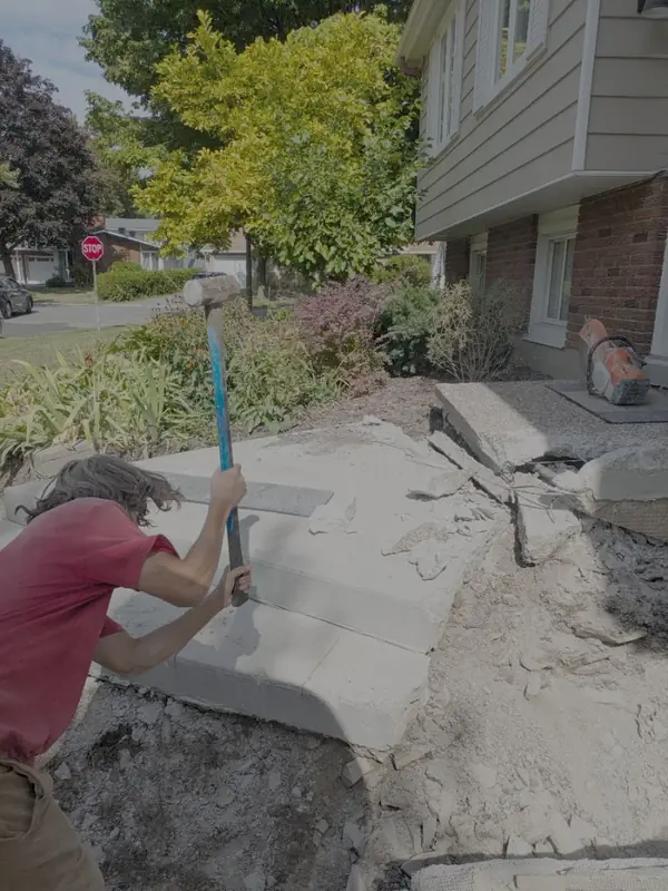 Old concrete steps being broken out with a sledgehammer