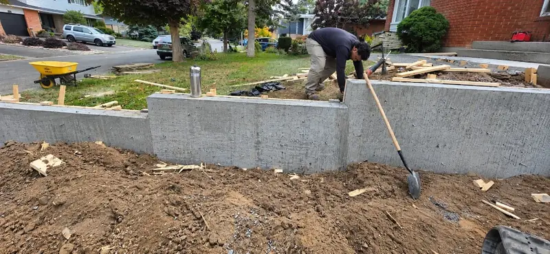 Crew member working on a new stepped concrete retaining wall