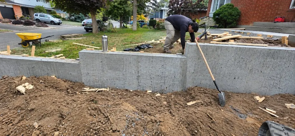 Crew member working on a new stepped concrete retaining wall