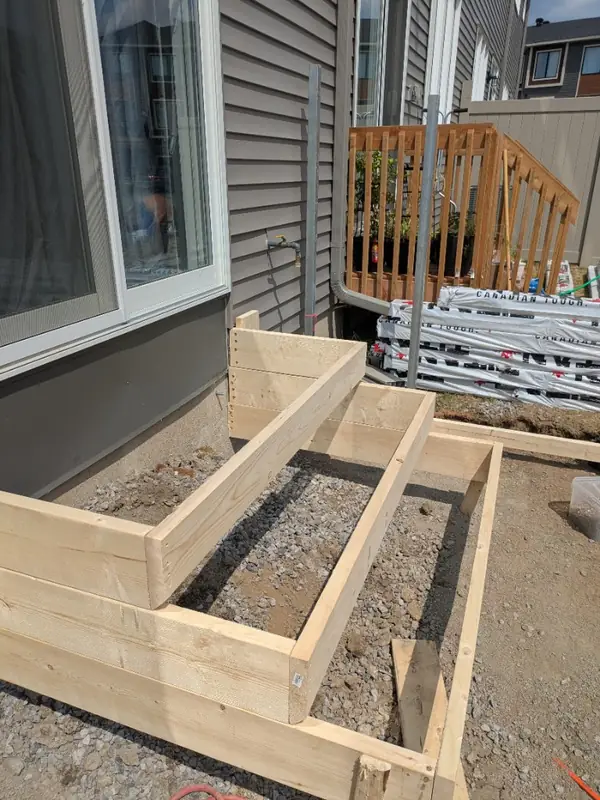 Wooden forms for new steps set on a compacted gravel base
